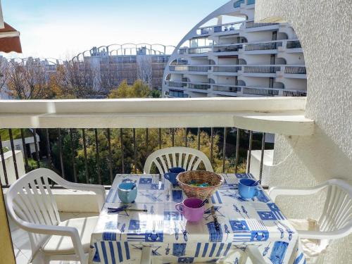 une table avec un chiffon de table bleu et blanc sur un balcon dans l'établissement Studio Ulysse Plage-12 by Interhome, à La Grande Motte