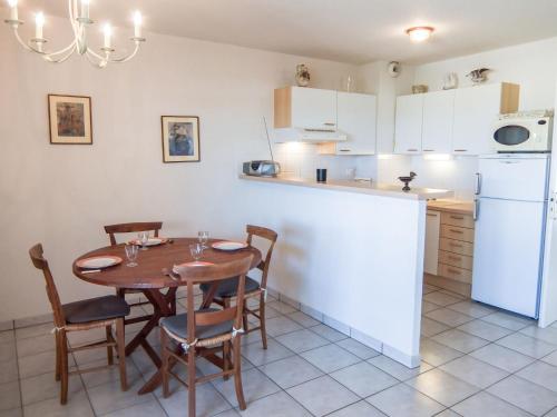 a kitchen with a wooden table and chairs and a counter at Apartment Les Flots Cypriano by Interhome in Saint-Cyprien-Plage