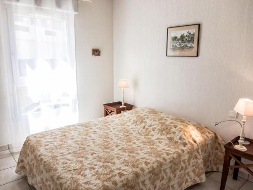 une chambre avec un lit et deux lampes et une fenêtre dans l'établissement Apartment Les Flots Cypriano by Interhome, à Saint Cyprien Plage