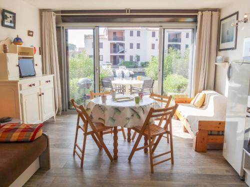 une cuisine et une salle à manger avec une table et des chaises dans l'établissement Apartment Marina 2-2 by Interhome, à Saint Cyprien Plage