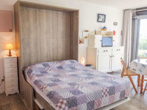 サン・シプリアン・プラージュにあるApartment Marina 2-2 by Interhomeのベッドルーム1室(ベッド1台、テーブル、冷蔵庫付)