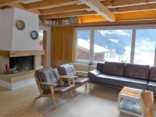 a living room with a couch and chairs and a fireplace at Apartment Chalet Casa Almis 5 by Interhome in Grindelwald