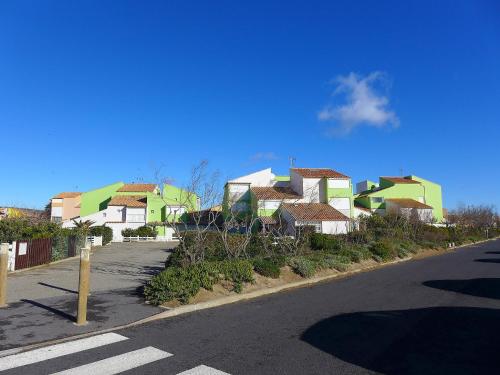 un groupe de maisons sur le côté d'une rue dans l'établissement Apartment Les Balcons de la Méditerranée-16 by Interhome, à Narbonne-Plage