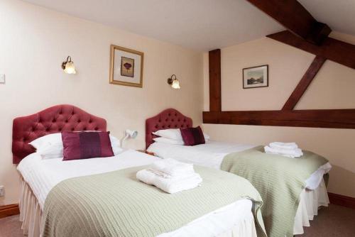 グラスミアにあるLow Croft Cottageのベッド2台 ホテルルーム 赤い椅子付