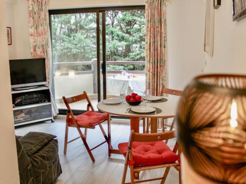 sala de estar con mesa, sillas y TV en Apartment Le Fairway-1 by Interhome, en Deauville