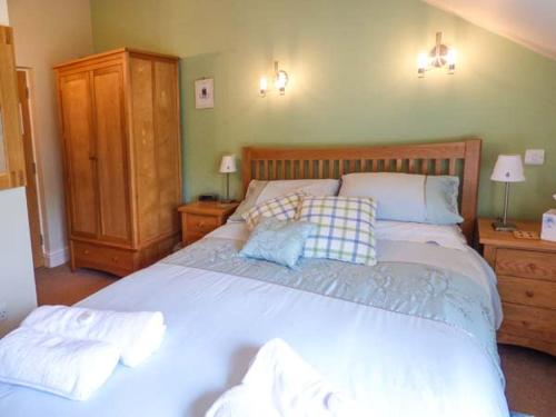 een slaapkamer met een groot bed met 2 kussens bij Bluebird Loft in Coniston