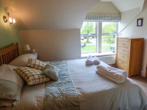 una camera da letto con un letto e due asciugamani di Bluebird Loft a Coniston