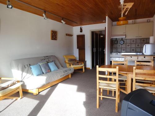 ein Wohnzimmer mit einem Sofa und einem Tisch sowie eine Küche in der Unterkunft Apartment Le Super Venosc by Interhome in Les Deux Alpes