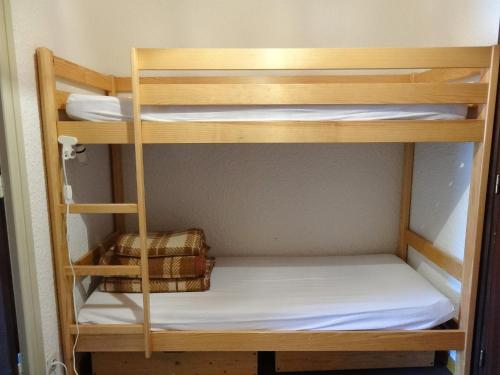 ein Etagenbett aus Holz mit einer weißen Matratze in einem Zimmer in der Unterkunft Apartment Le Super Venosc by Interhome in Les Deux Alpes
