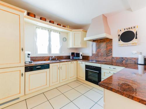 a kitchen with wooden cabinets and a counter top at Villa l'Occitane by Interhome in Agde