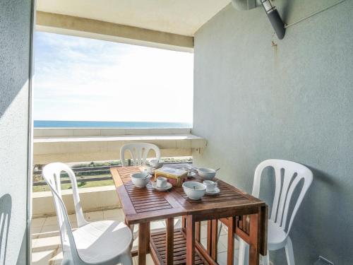 カネ・アン・ルシヨンにあるApartment Le Beaupré-9 by Interhomeの海の景色を望む客室で、テーブルと椅子が備わります。