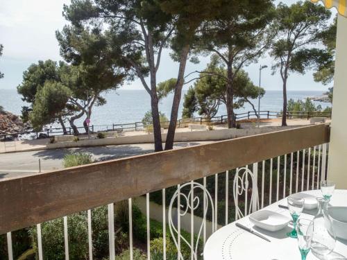 a table on a balcony with a view of the ocean at Apartment La Calanque d'Or by Interhome in Bandol