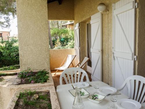 une table blanche et des chaises sur une terrasse dans l'établissement Apartment Super Ile Rousse by Interhome, à Bandol