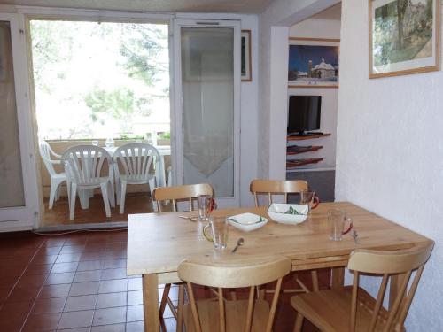 une salle à manger avec une table et des chaises en bois dans l'établissement Apartment Super Ile Rousse by Interhome, à Bandol