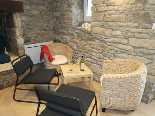 PlozévetにあるHoliday Home Ty Coz - PZV 106 by Interhomeの椅子とテーブル(ワイン1本付)が備わる客室です。