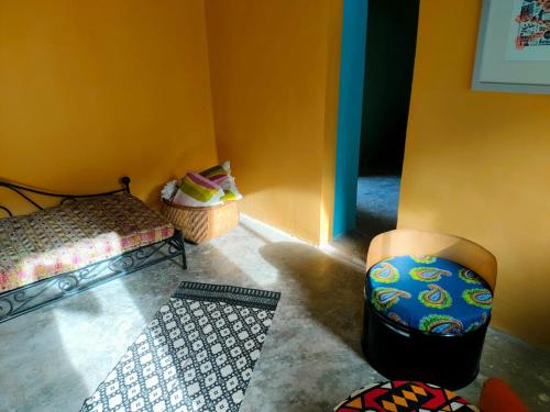 a room with two beds and a chair in it at Gîte hicking bas in Xá Xá