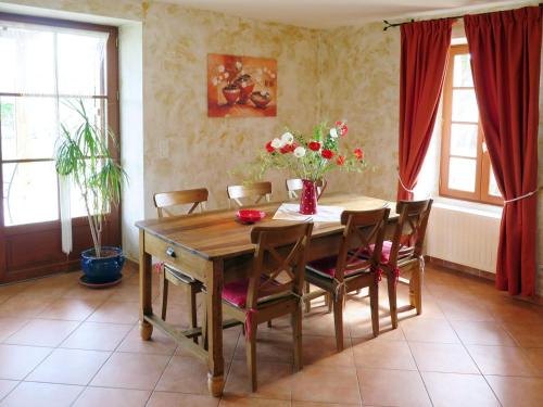 une table à manger avec des chaises et un vase de fleurs dans l'établissement Holiday Home Madaillan by Interhome, à Madaillan