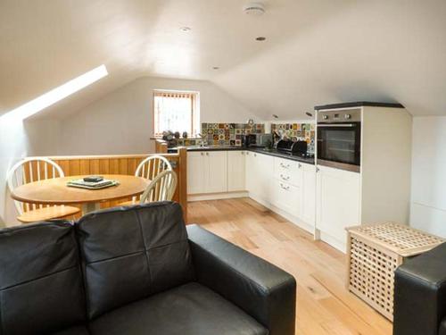 uma sala de estar com um sofá, uma mesa e uma cozinha em Town End Barn em Bradwell