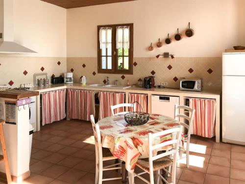 une cuisine avec une table et des chaises dans une cuisine dans l'établissement Holiday Home La Gaubide by Interhome, à Lalandusse