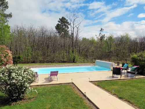 a swimming pool in a yard with chairs around it at Holiday Home Au Cayroux by Interhome in Blanquefort-sur-Briolance