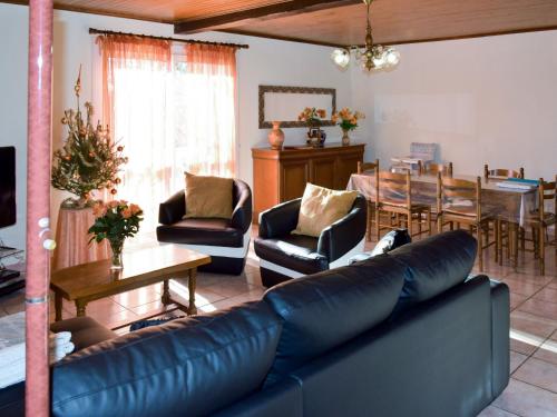 a living room with a couch and a dining room at Holiday Home Le Coustal by Interhome in Blanquefort-sur-Briolance