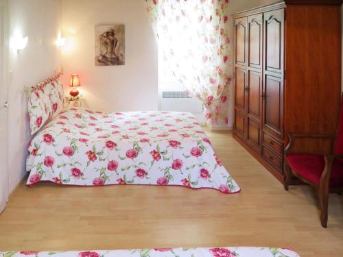 a bedroom with a bed with a pink floral bedspread at Holiday Home Le Coustal by Interhome in Blanquefort-sur-Briolance