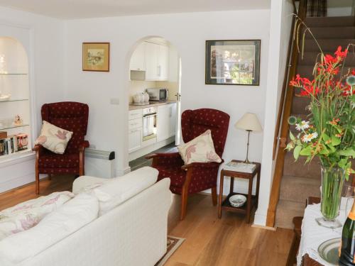LevensにあるCoachmans Cottageのリビングルーム(白いソファ、椅子付)