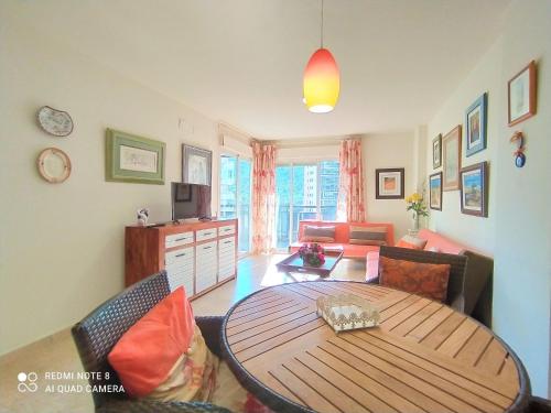 sala de estar con mesa de madera y sofá en Apartment Sidney by Interhome, en Cala de Finestrat