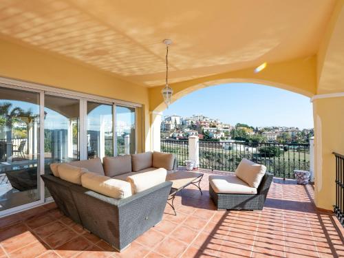 ein Wohnzimmer mit Sofa und Stühlen auf dem Balkon in der Unterkunft Holiday Home Villa Unica by Interhome in Fuengirola