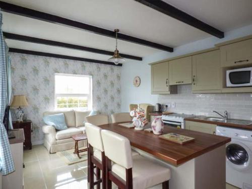 a kitchen with a table and a living room at No 1 Apt, Brandy Harbour Cottage in Kilcolgan