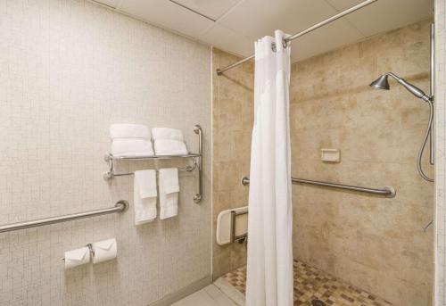 een badkamer met een douche en witte handdoeken bij Clarion Pointe New Bern in New Bern
