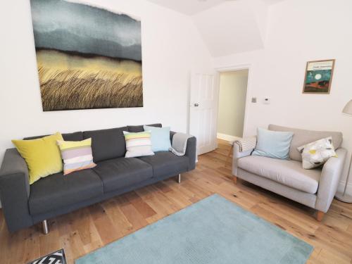 a living room with a couch and a painting on the wall at Teviot Cottage in Corbridge