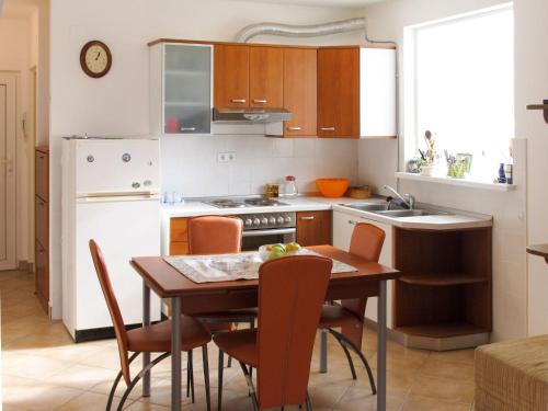 - une cuisine avec une table, des chaises et un évier dans l'établissement Apartment Vivoda - PUL168 by Interhome, à Štinjan