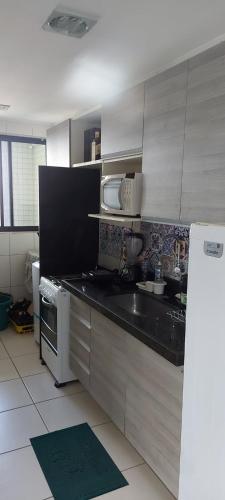 a kitchen with a sink and a microwave at Residencial Amazonia Apto 1205 in João Pessoa