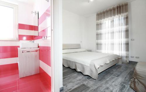 Dormitorio pequeño con cama y rayas rojas y blancas en Casa "CrauNari", en Pozzallo