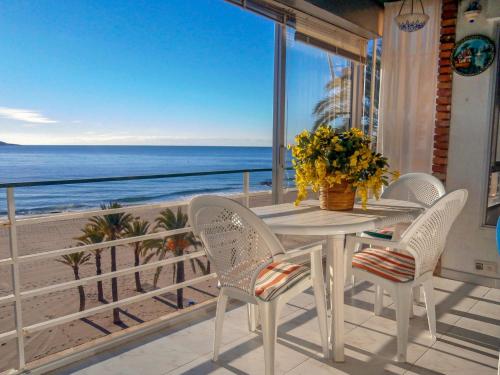 a white table and chairs on a balcony with the beach at Apartment Turia Playa by Interhome in Benidorm