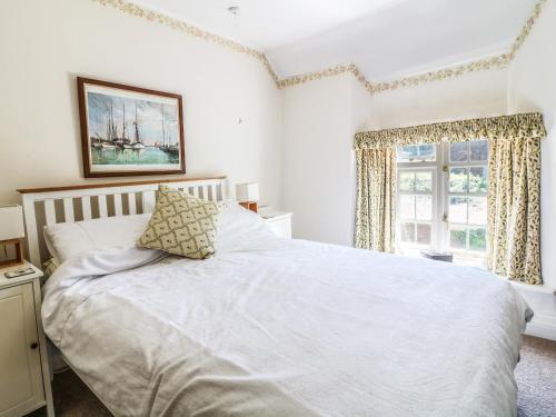 a bedroom with a white bed and a window at Old Hammetts in Woolfardisworthy
