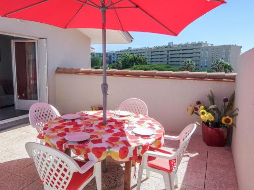 サン・シプリアン・プラージュにあるApartment Le Clos de St Cyprien by Interhomeの赤いテーブル(白い椅子、赤い傘付)