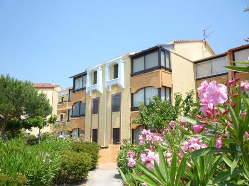 un immeuble avec des fleurs devant lui dans l'établissement Apartment Les Mas de La Mer-6 by Interhome, à Saint Cyprien Plage