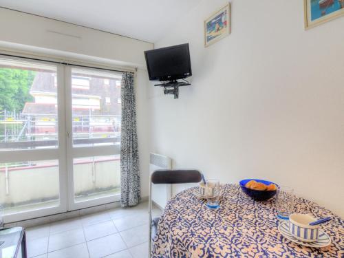 um quarto com uma mesa, uma televisão e uma janela em Studio Les Flots Bleus-1 by Interhome em Trouville-sur-Mer
