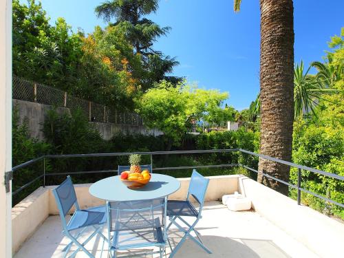 - une table avec des chaises et une corbeille de fruits sur la terrasse dans l'établissement Holiday Home Villa Esmeralda by Interhome, à Cannes