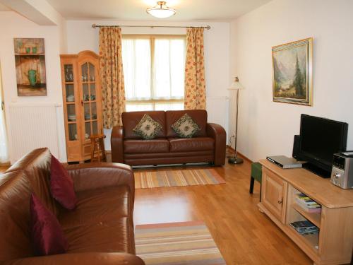 uma sala de estar com um sofá e uma televisão em Apartment Bibelöd-2 by Interhome em Ruhpolding