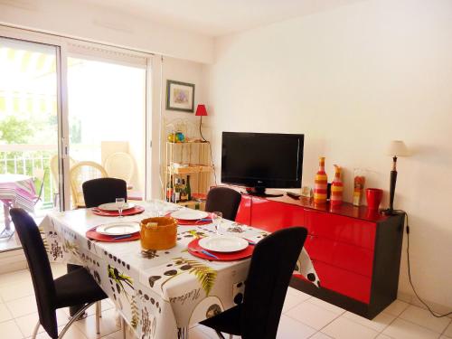 une salle à manger avec une table avec des chaises et une télévision dans l'établissement Apartment Résidence Les Jardins d'Eden by Interhome, à Saint-Raphaël