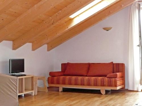 - un salon avec un canapé rouge et une télévision dans l'établissement Apartment Bibelöd-5 by Interhome, à Ruhpolding