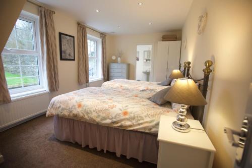 a bedroom with a bed and a lamp on a table at Waterfall Cottage in Launceston