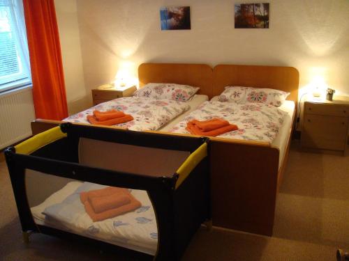 a bedroom with a bed with orange towels on it at Apartment Altes Forsthaus Sösetal by Interhome in Riefensbeek