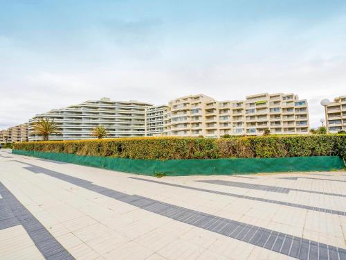 una pasarela frente a un gran edificio de apartamentos en Apartment Les Trois Mâts-4 by Interhome, en Canet-en-Roussillon