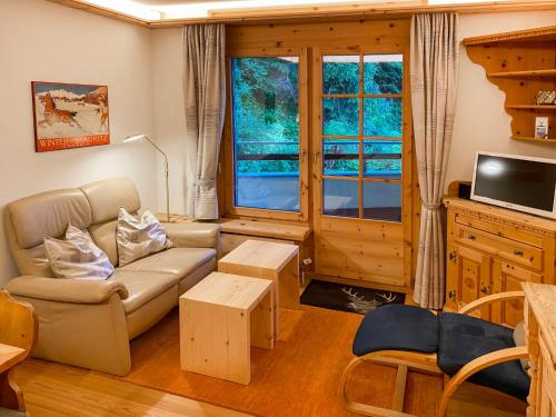 a living room with a couch and a tv at Apartment Chesa Alvetern 5 by Interhome in Sils Maria