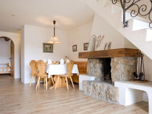 a dining room with a table and a fireplace at Apartment Chesa Chanella 5 by Interhome in La Punt-Chamues-ch