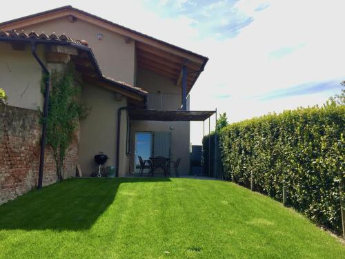 een huis met een tuin met een groen gazon bij Holiday Home Cascina-2 by Interhome in Costigliole dʼAsti